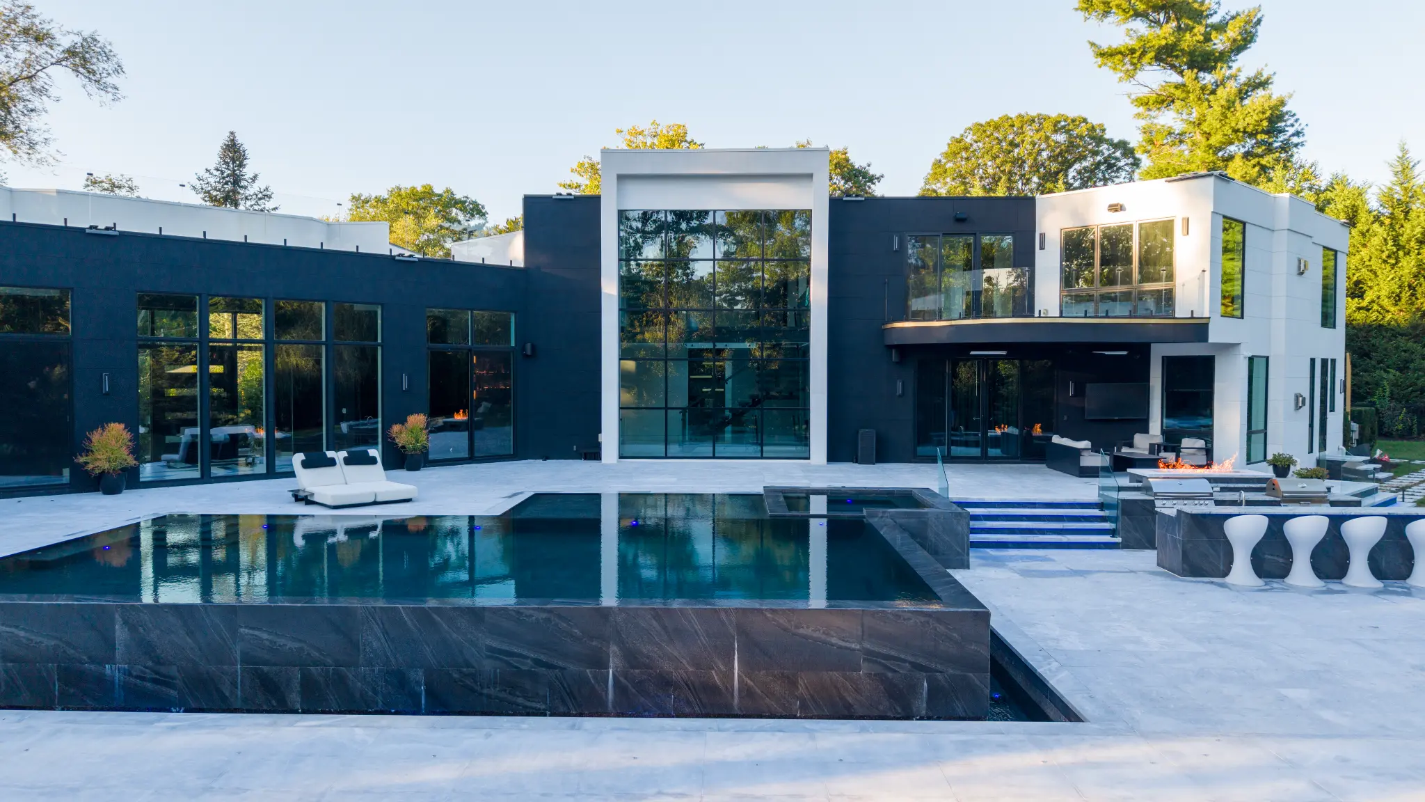Modern dark-water pool and attached spa beside a contemporary Kings Point residence